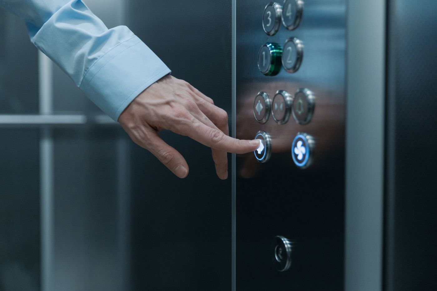 Mano presionando el botón de un elevador